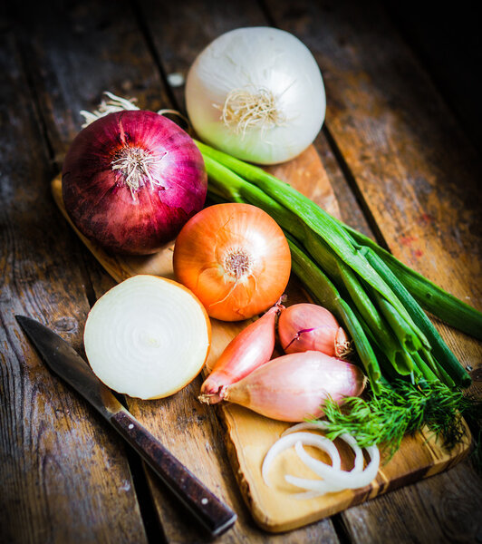 Colorful onions and garlic on rustic wooden background