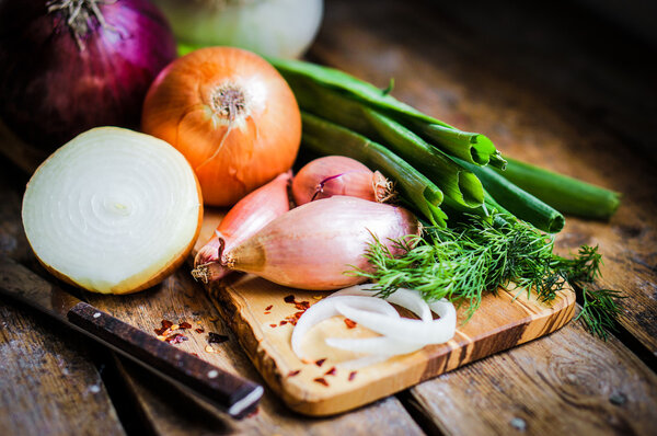 Colorful onions and garlic on rustic wooden background