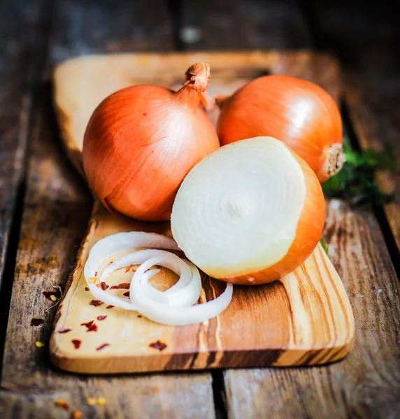 Πολύχρωμο κρεμμύδια και το σκόρδο σε ρουστίκ ξύλινα φόντο — Φωτογραφία Αρχείου