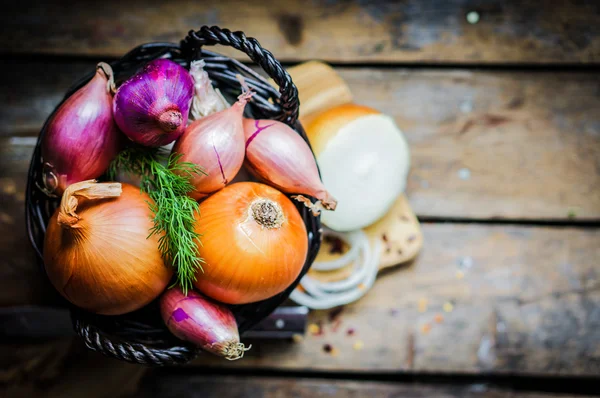 Cebollas coloridas y ajo sobre fondo rústico de madera —  Fotos de Stock