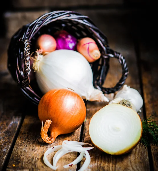 Colorful onions and garlic on rustic wooden background — Stock Photo, Image