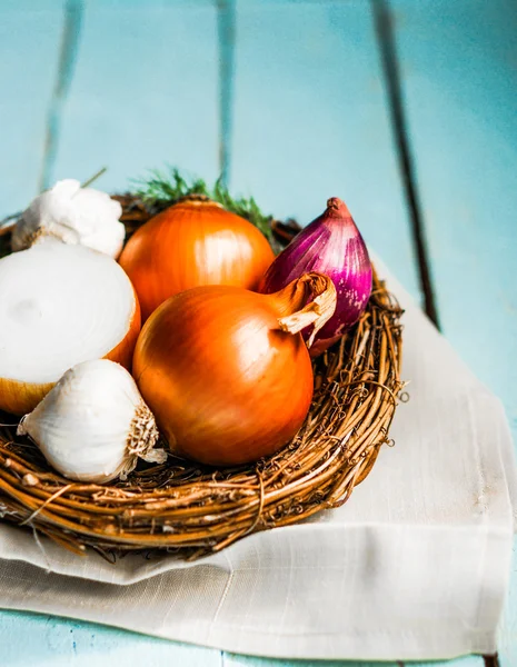 Colorful onions and garlic on rustic wooden background — Stock Photo, Image
