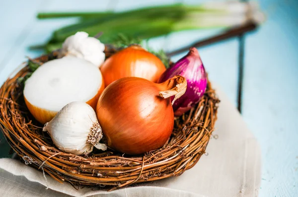 Colorful onions and garlic on rustic wooden background — Stock Photo, Image