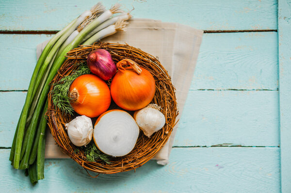 Colorful onions and garlic on rustic wooden background
