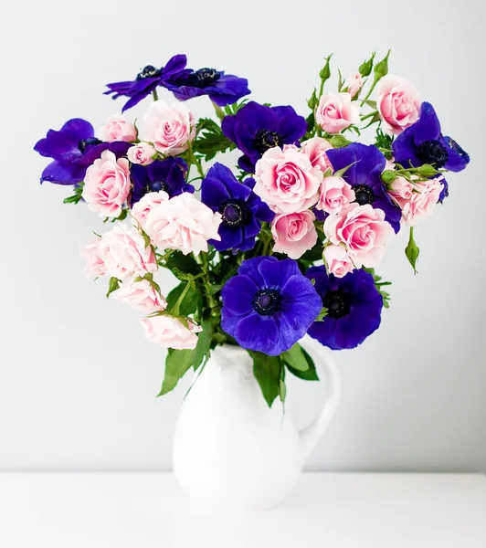 Strauss aus rosa Rosen und blauen Anemonen in weißer Vase — Stockfoto