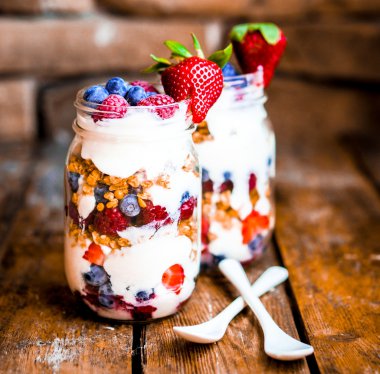 Granola yoğurt ve rustik zemin üzerine çilek parfe