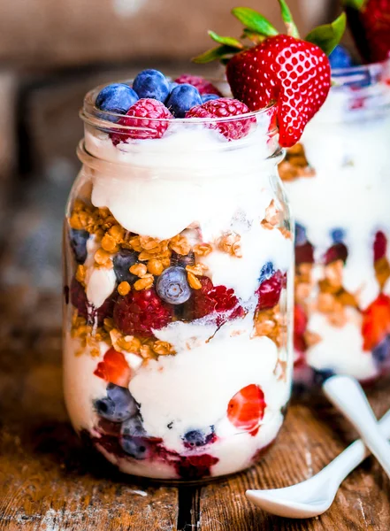Гранола парфе з йогуртом і ягоди на сільському стилі тла — стокове фото
