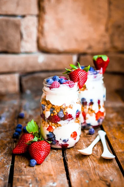 Granola Parfait с йогуртом и ягодами на деревенском фоне — стоковое фото
