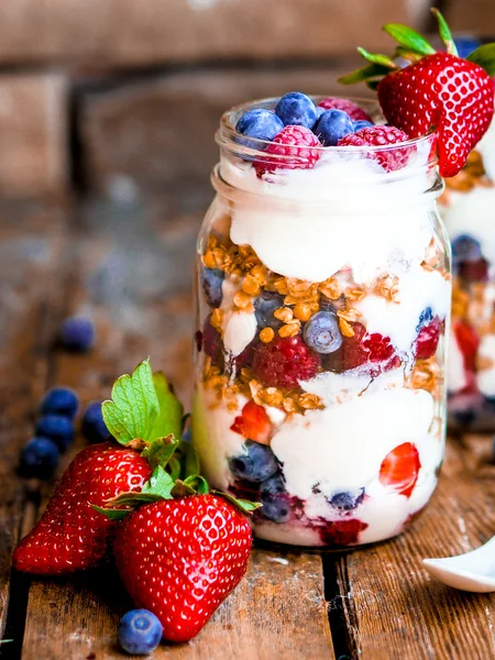 Müsli-Parfait mit Joghurt und Beeren auf rustikalem Hintergrund — Stockfoto