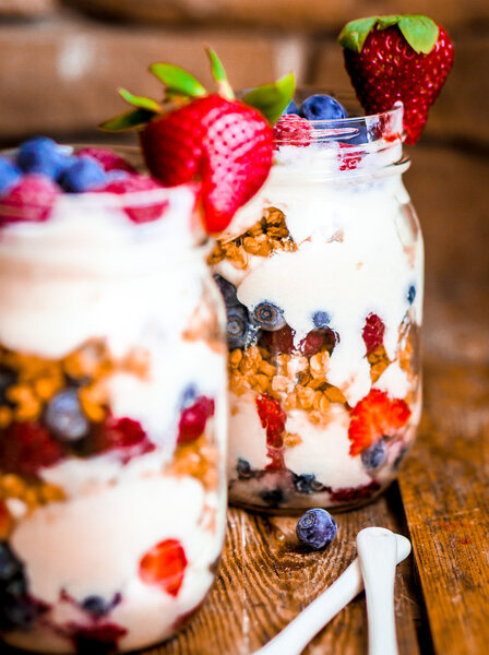 Granola Parfait with yogurt and berries on rustic background