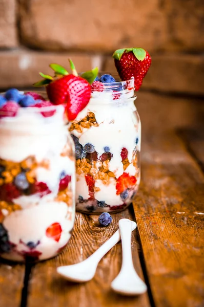 Muesli parfait met yoghurt en bessen op rustieke achtergrond — Stockfoto