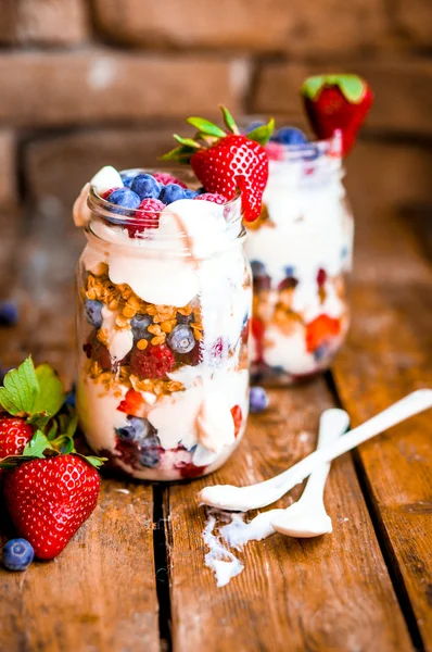 Muesli parfait met yoghurt en bessen op rustieke achtergrond — Stockfoto