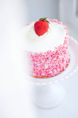 ahşap zemin üzerinde beyaz kremalı Çilekli pasta