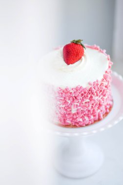 ahşap zemin üzerinde beyaz kremalı Çilekli pasta