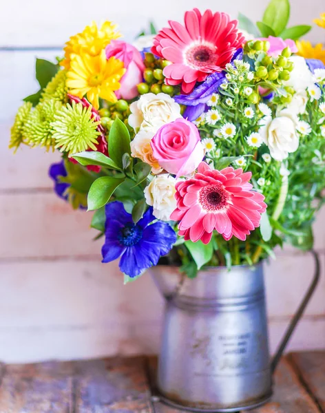 Buquê colorido de flores da primavera em vaso vintage no fundo de madeira rústica — Fotografia de Stock