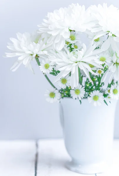 Ромашки в белой вазе на деревянном фоне — стоковое фото