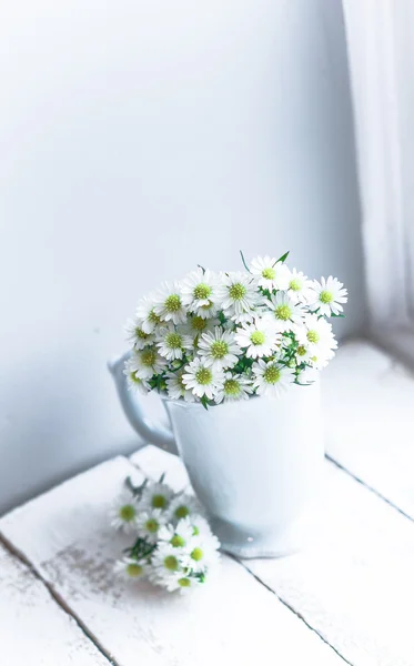 Margeriten in weißer Vase auf hölzernem Hintergrund — Stockfoto