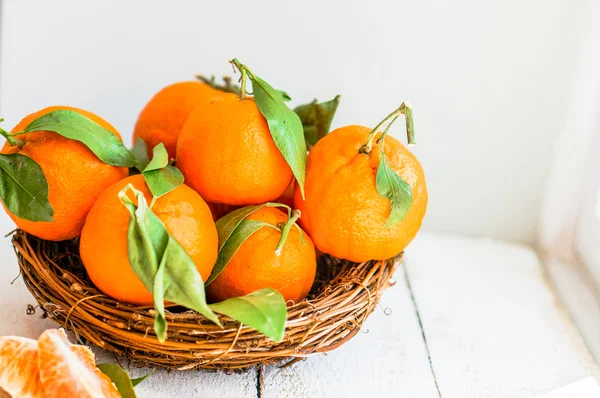 Tangerines in the basket on wooden background — Stock Photo, Image