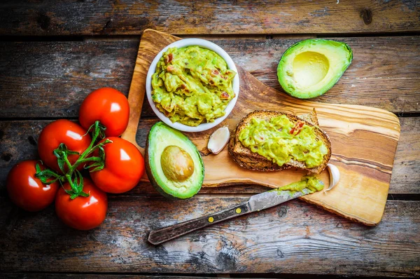 Guacamaole dengan roti dan alpukat pada latar belakang kayu pedesaan — Stok Foto