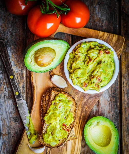 Guacamaole with bread and avocado on rustic wooden background — Stock Photo, Image