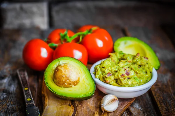 Guacamaole com pão e abacate sobre fundo de madeira rústica — Fotografia de Stock