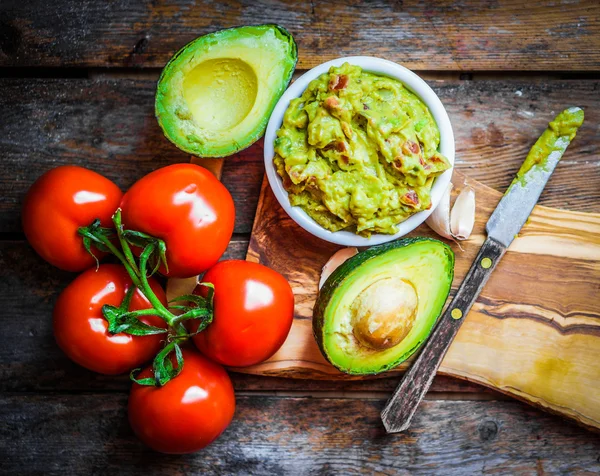 Guacamaole com pão e abacate sobre fundo de madeira rústica — Fotografia de Stock