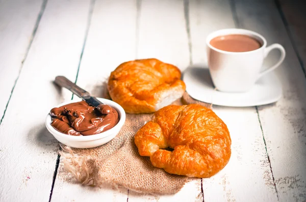 Färska bakat croissanter med choklad grädde och varm kakao — Stockfoto