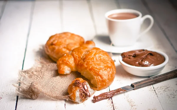 Färska bakat croissanter med choklad grädde och varm kakao — Stockfoto