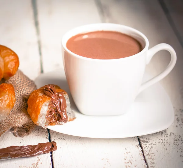 Färska bakat croissanter med choklad grädde och varm kakao — Stockfoto