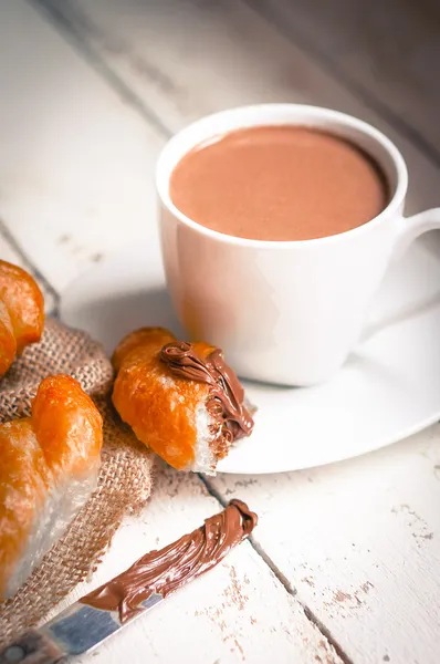 Croissants frais au four à la crème au chocolat et au cacao chaud — Photo