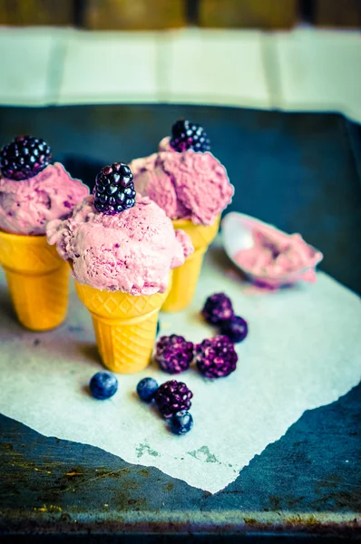 Helado en conos con bayas sobre fondo rústico de madera — Foto de Stock