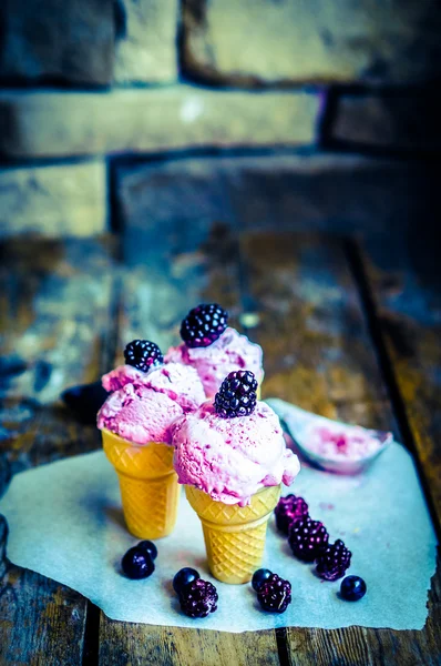 Морозиво в конусах з ягодами на сільському дерев'яному фоні — стокове фото