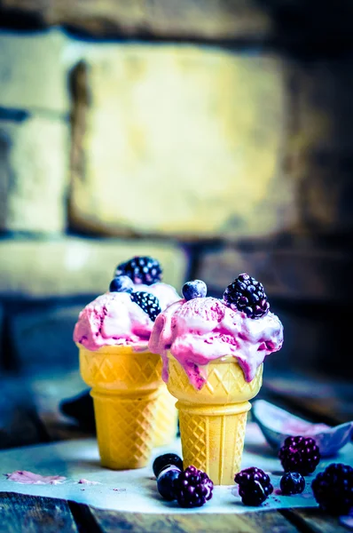 Ice -cream in cones with berries on rustic wooden background — Stock Photo, Image