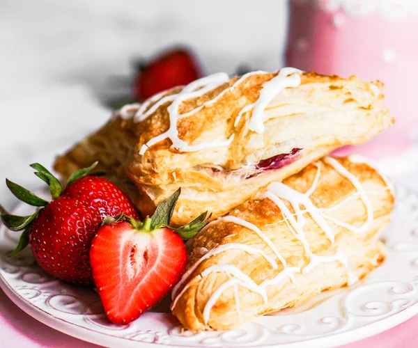 Färska croissanter med jordgubbar på trä bakgrund — Stockfoto