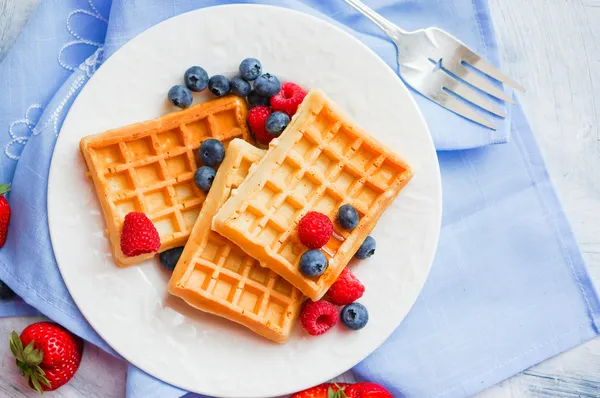 Waffles belgas com bagas no fundo rústico — Fotografia de Stock