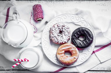 süt ve rustik ahşap zemin üzerinde çeşitli çörekler