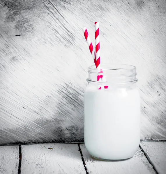 Milk jar on wooden rustic background — Stock Photo, Image