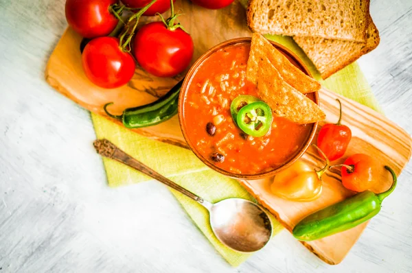 Hot and spicy fresh made Mexican chili soup on rustic background — Stock Photo, Image