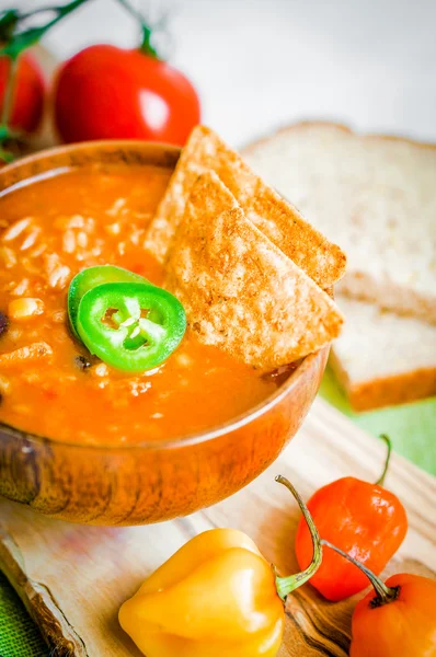 Горячий и острый свежий мексиканский суп чили на деревенском фоне — стоковое фото