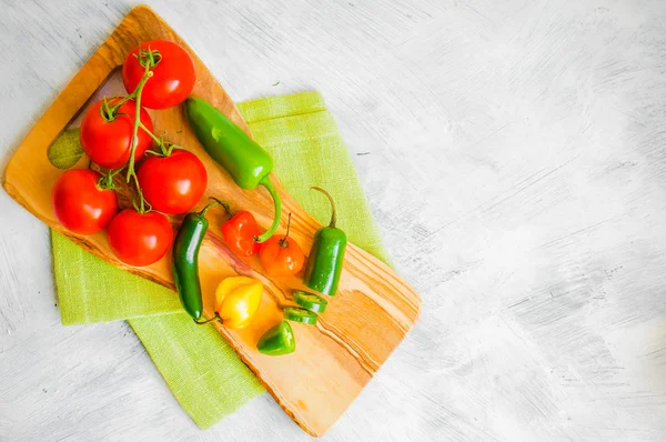 Geassorteerde peper en tomaten op houten achtergrond Stockfoto