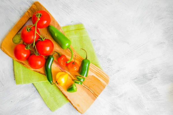 Diverse paprika och tomater på trä bakgrund Stockbild