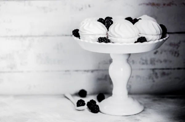 Meringue cookies witj blackberries on rustic background — Stock Photo, Image