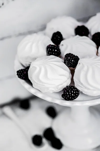 Galletas de merengue witj moras sobre fondo rústico —  Fotos de Stock