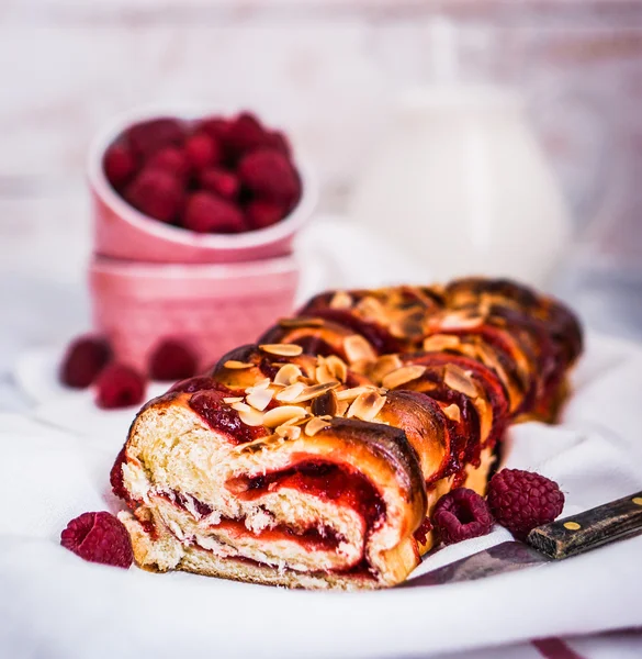 Raspberry cake with almonds on wooden background — Stock Photo, Image