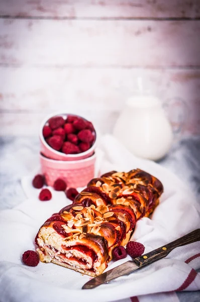 Raspberry cake with almonds on wooden background — Stock Photo, Image