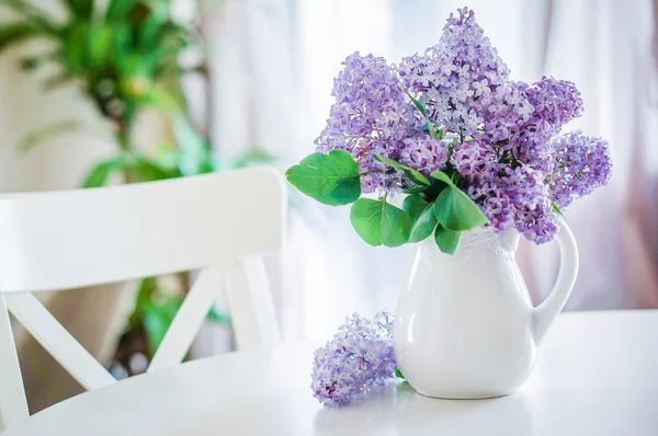 Lilacs in white vase in the kitchen — Stock Photo, Image