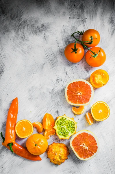 Orange fruits and vegetables on rustic background — Stock Photo, Image