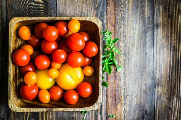 Tomates coloridos sobre fondo rústico — Foto de Stock