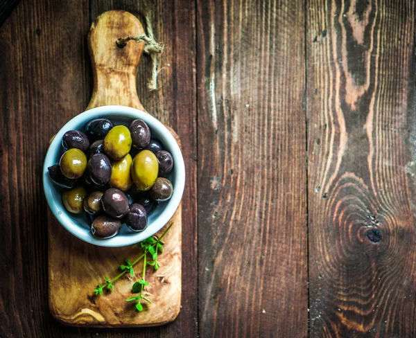 Olivy na rustikální dřevěné pozadí — Stock fotografie