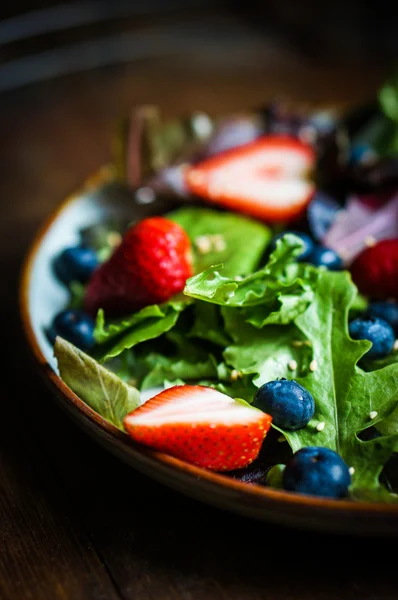 Ahşap zemin üzerinde meyveleri ile yeşil salata — Stok fotoğraf